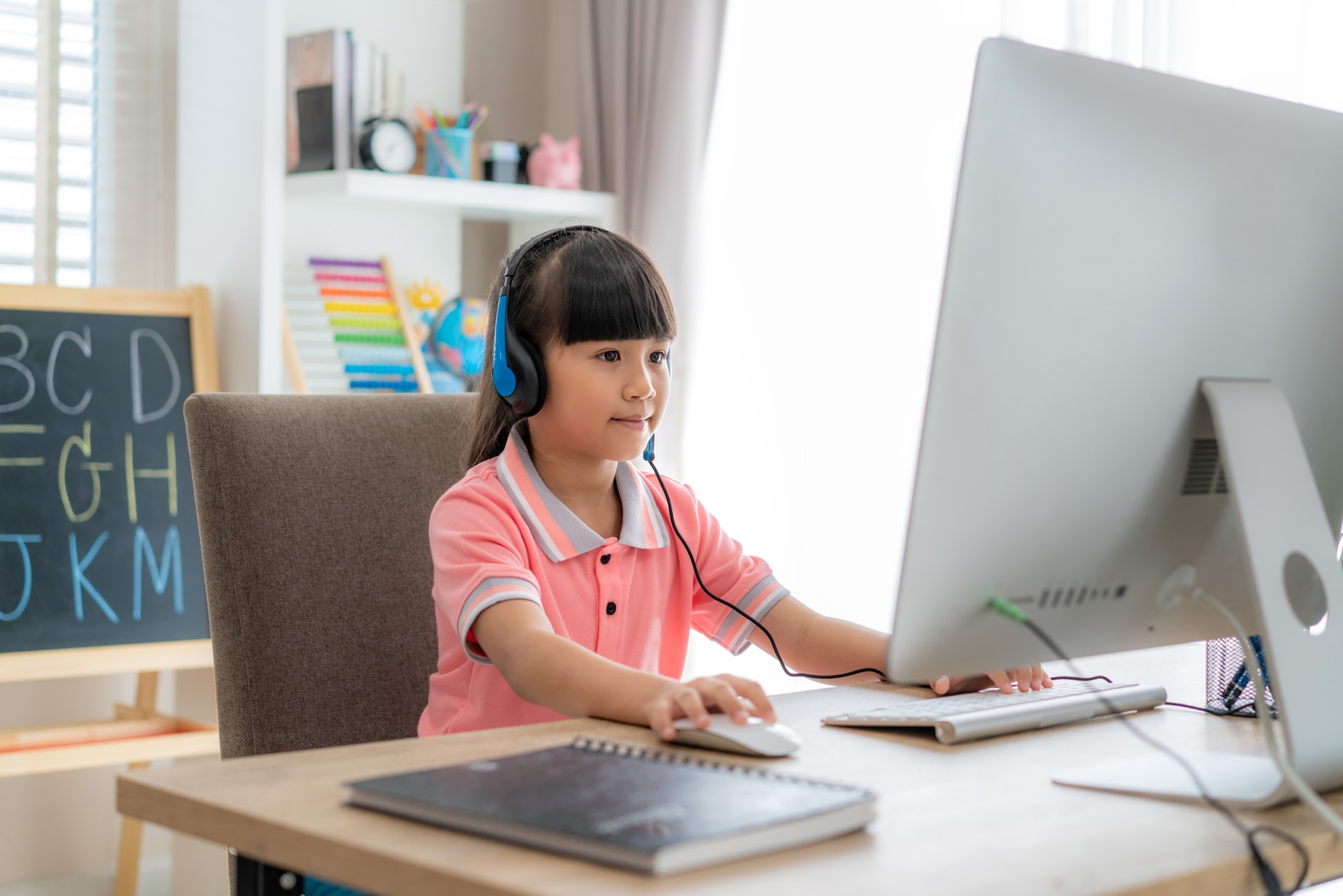 Asian girl student video conference e-learning with teacher on computer in living room at home. Homeschooling and distance learning ,online ,education and internet protect from COVID-19 viruses.